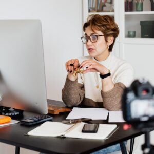 Confident elegant lady in eyeglasses hosting webinar